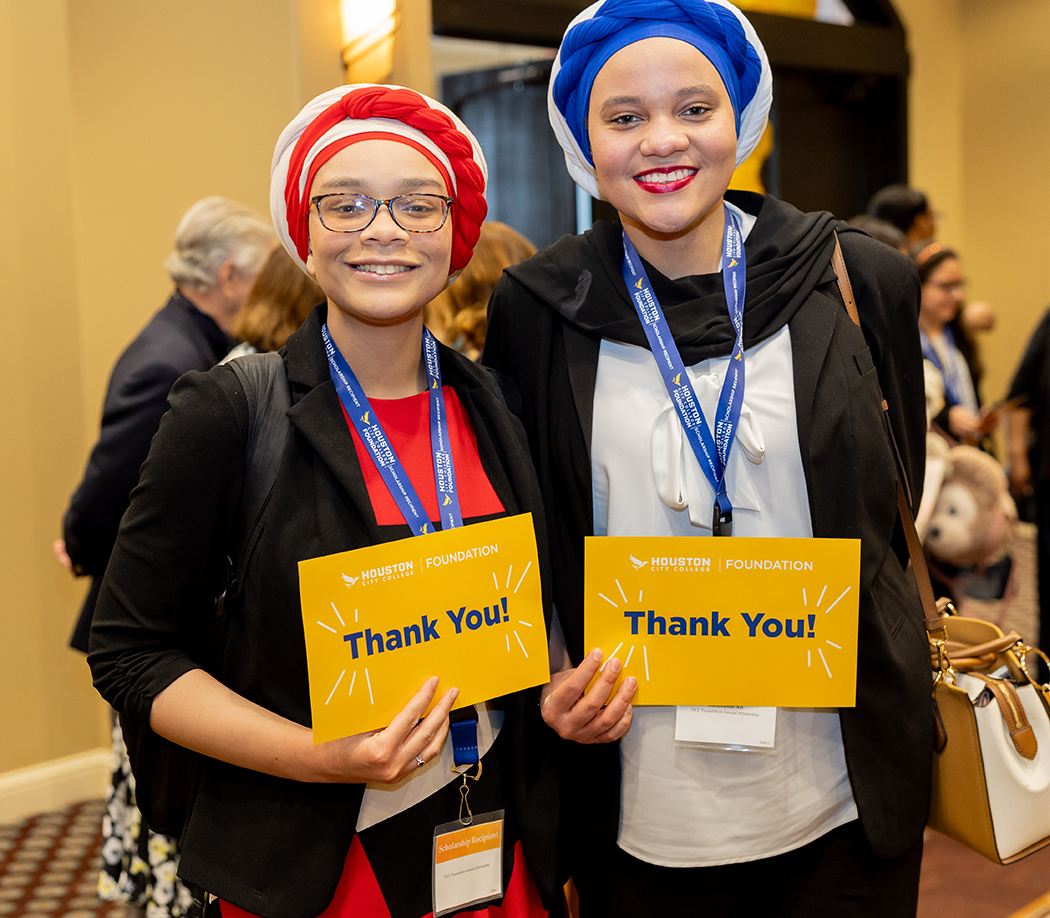 Two scholarship recipients smiling and holding &ldquo;Thank You&rdquo; cards at the Houston City College Foundation Scholarship Luncheon.